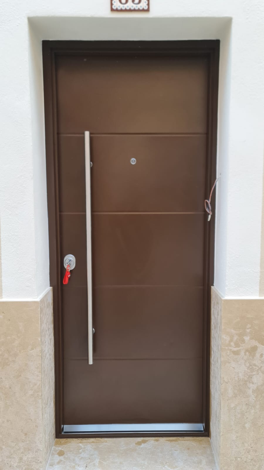 Puerta acorazada K-XXI marrón RAL 8014 con manillón largo